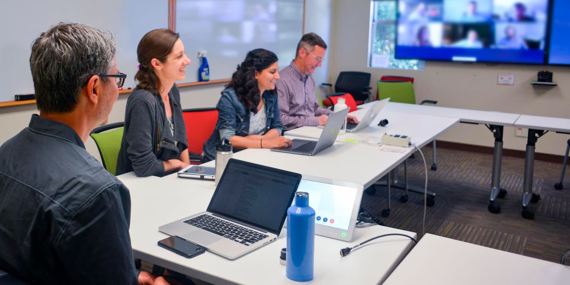 Web Services team members in a meeting with remote employees